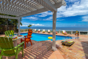 poolside pergola seating and games at Casa de Vista St Croix Vacation Rental